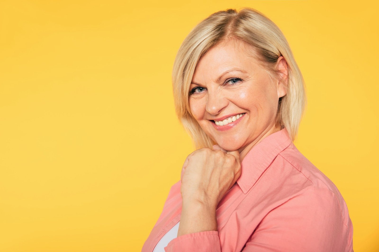 close-up-photo-happy-smiling-beautiful-cute-lovely-blonde-senior-woman-with-beauty-clean-skin-casual-wear-isolated-yellow-background-min